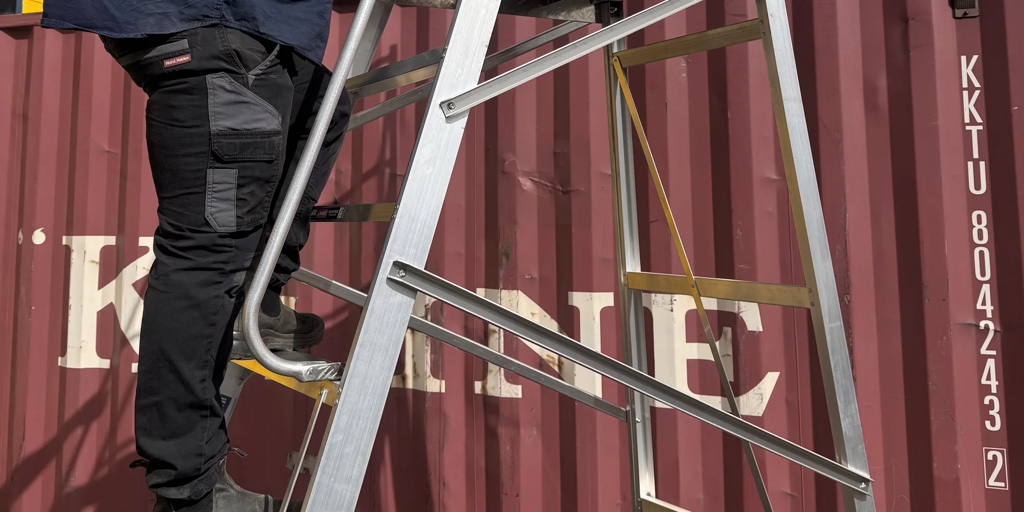Worker climbing a REX STEP 200kg aluminium platform ladder